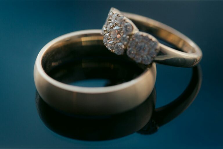A person photographs a diamond ring beside an appraisal document and organized jewelry box.